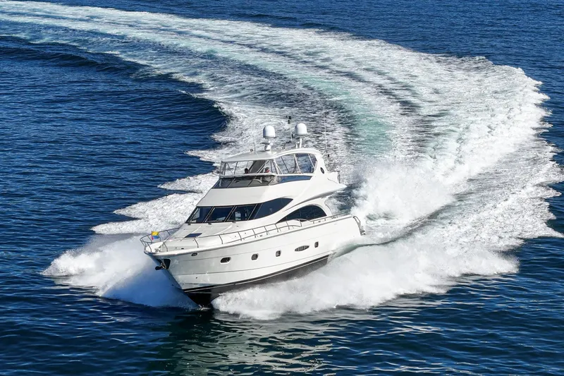 Slide: The Image of Luxurious 2005 Marquis 65 yacht cruising swiftly on open blue waters. - 11