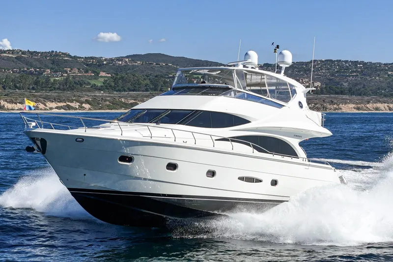 Slide: The Image of Luxurious 2005 Marquis 65 yacht cruising on open water with scenic coastline backdrop. - 14