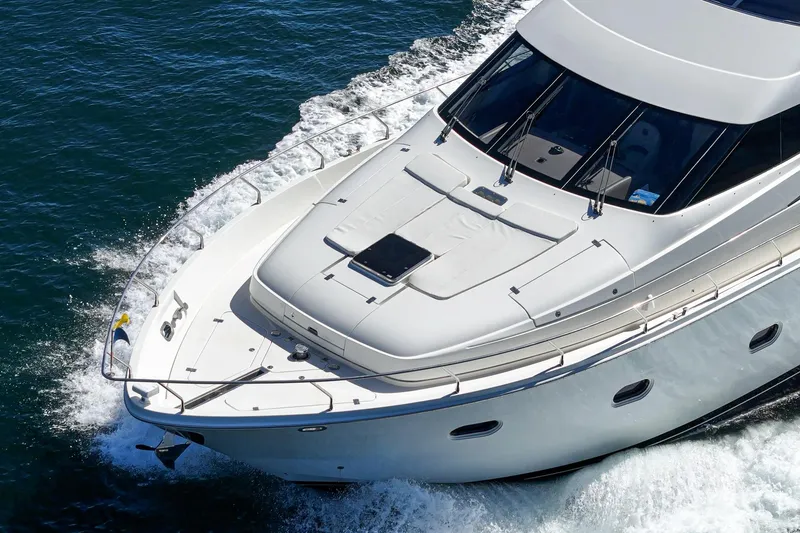 Slide: The Image of Luxury 2005 Marquis 65 yacht cruising on open water, showcasing sleek design and elegance. - 18