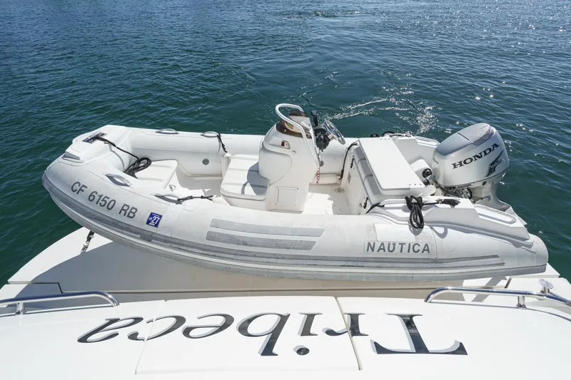 Slide: The Image of Inflatable boat with Honda motor on a 2005 Marquis 65 yacht, docked on water. - 32