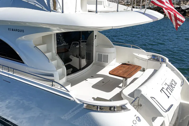 Slide: The Image of Luxury 2005 Marquis 65 yacht with elegant deck and American flag, docked on serene waters. - 35