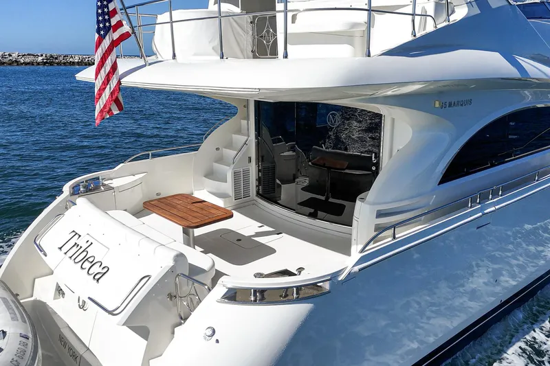 Slide: The Image of Luxury 2005 Marquis 65 yacht with American flag, docked in serene waters. - 37