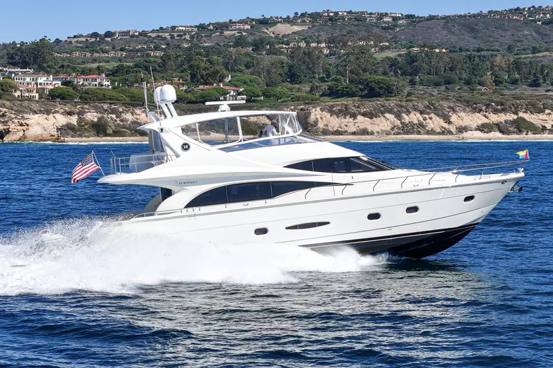 Slide: The Image of Luxury 2005 Marquis 65 yacht cruising near scenic coastline. - 4