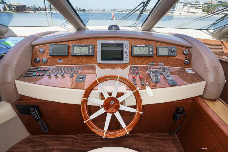 Slide: The Image of Luxurious 2005 Marquis 65 yacht helm with advanced navigation controls and wooden steering wheel. - 56