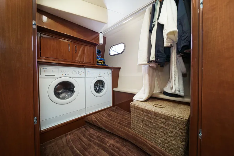 Slide: The Image of Laundry room inside a 2005 Marquis 65 yacht with washer, dryer, and storage. - 62