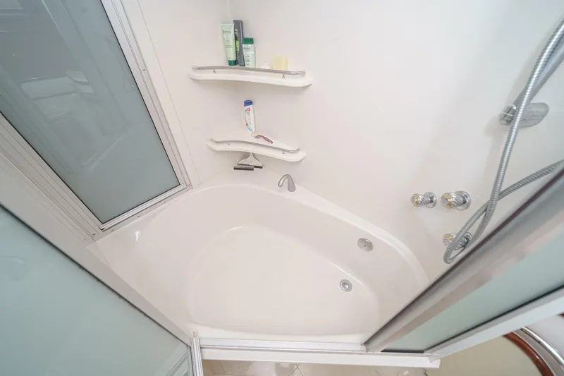 Slide: The Image of Luxurious 2005 Marquis 65 yacht bathroom with modern shower and bathtub amenities. - 67