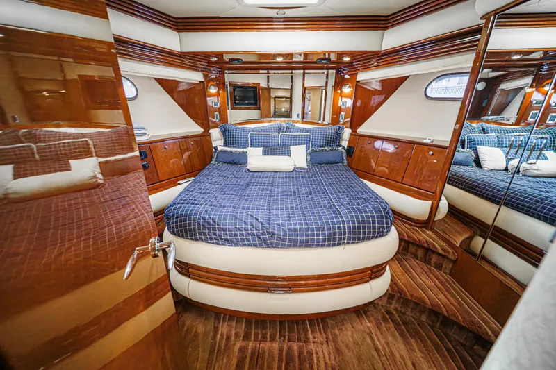 Slide: The Image of Luxurious 2005 Marquis 65 yacht bedroom with elegant wood finish and plush bedding. - 69