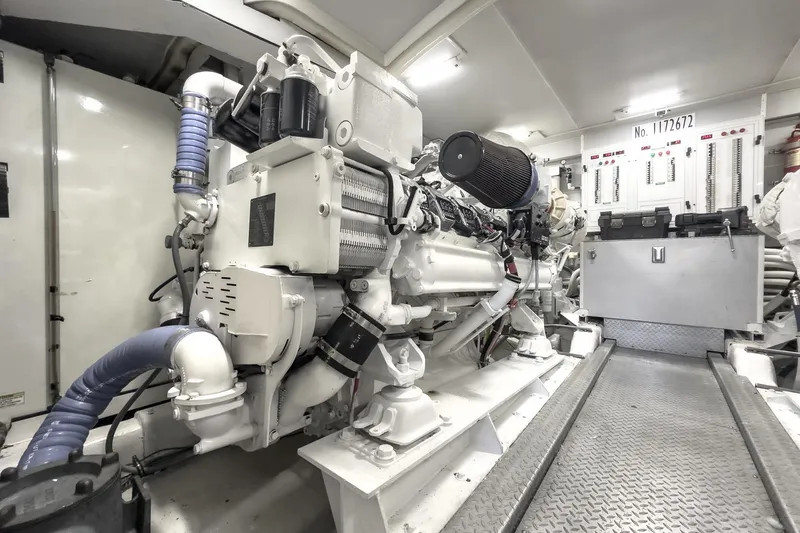Slide: The Image of Engine room of a 2005 Marquis 65 yacht, featuring complex machinery and control panels. - 79