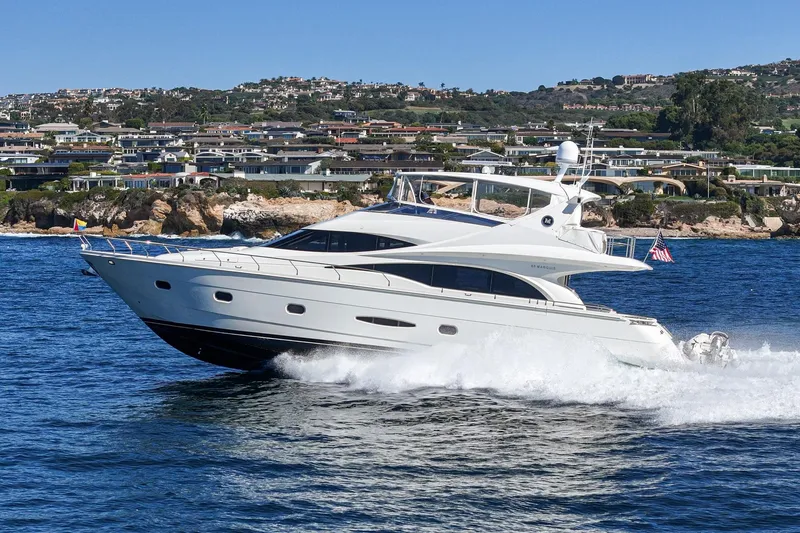 Slide: The Image of Luxury 2005 Marquis 65 yacht cruising near coastal homes, creating waves in the ocean. - 9