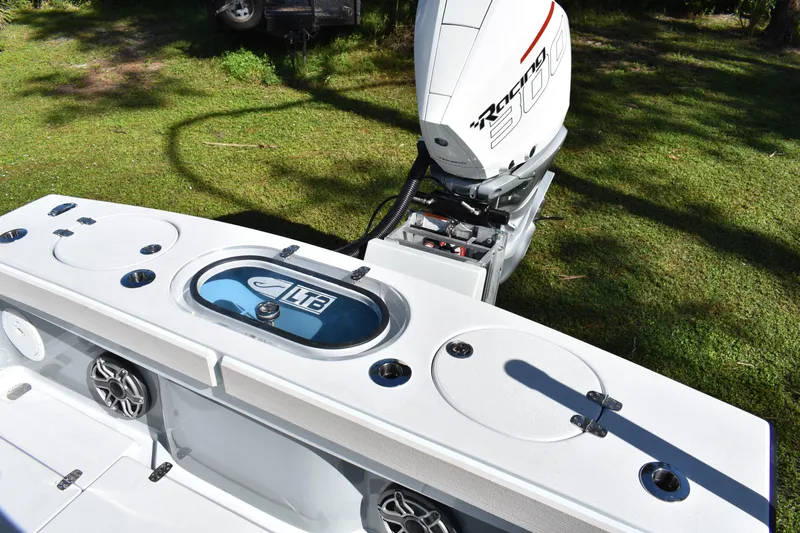 Slide: The Image of 2025 Latitude Tournament Boats 25 interior with seating and Yeti cooler, surrounded by lush greenery. - 21