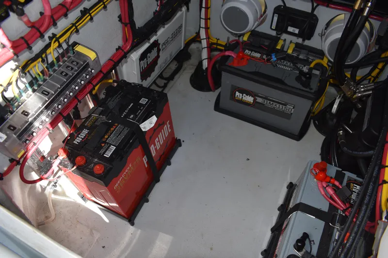 Slide: The Image of Battery compartment of 2025 Latitude Tournament Boats 25, featuring Pro-Guide batteries and wiring. - 33