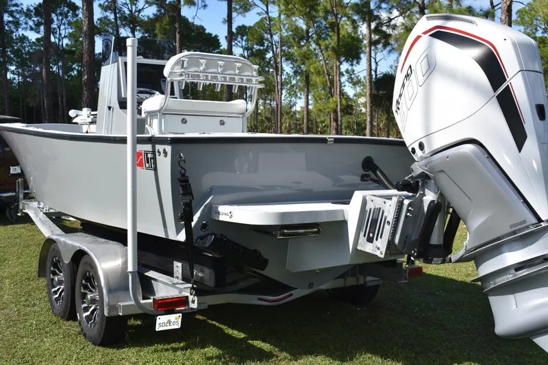 Slide: The Image of 2025 Latitude Tournament Boats 25 on trailer, parked on grass with trees in background. - 7