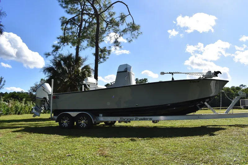 Slide: The Image of 2025 Latitude Tournament Boats 25 on trailer, parked in a scenic wooded area. - 9
