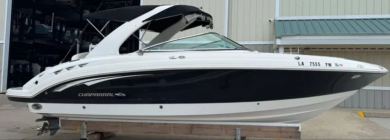 Slide: The Image of 2007 Chaparral SSX 276 boat with black and white exterior, docked in a marina. - 2