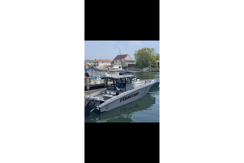 Slide: The Image of 2024 Fountain 38 SC boat docked at a marina, showcasing sleek design and powerful engines. - 5