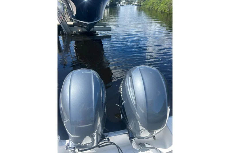 Slide: The Image of 2019 Sea Hunt Gamefish 27 with dual outboard motors on a calm waterway. - 12