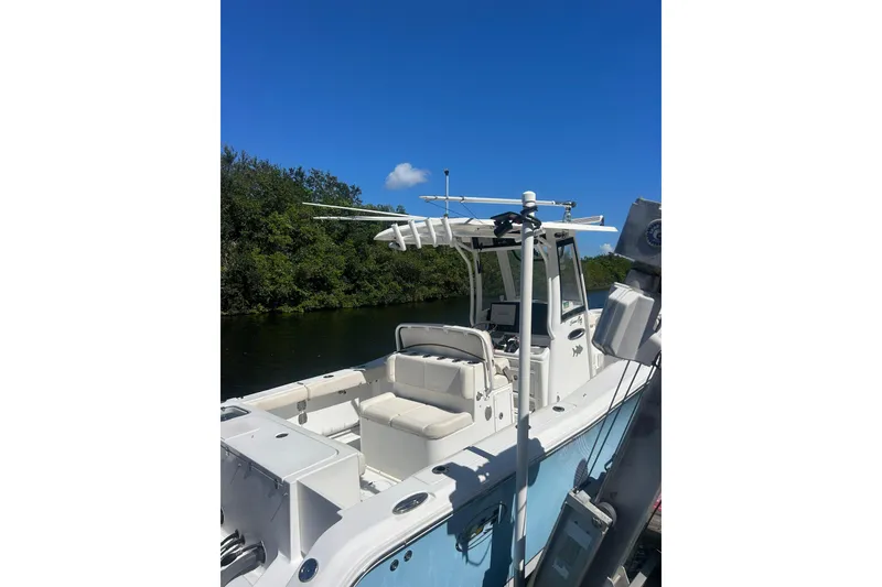 Slide: The Image of 2019 Sea Hunt Gamefish 27 boat docked, featuring spacious seating and clear blue skies. - 2