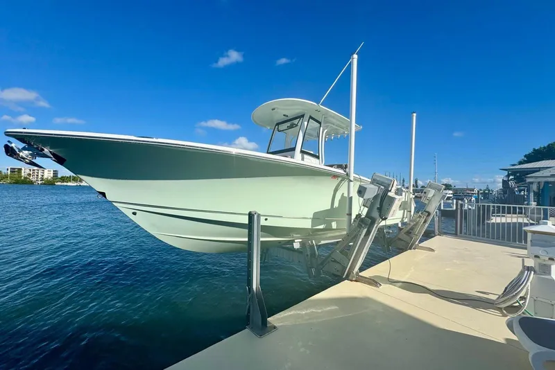 Slide: The Image of 2019 Sea Hunt Ultra 275 SE boat on lift by waterfront dock. - 13