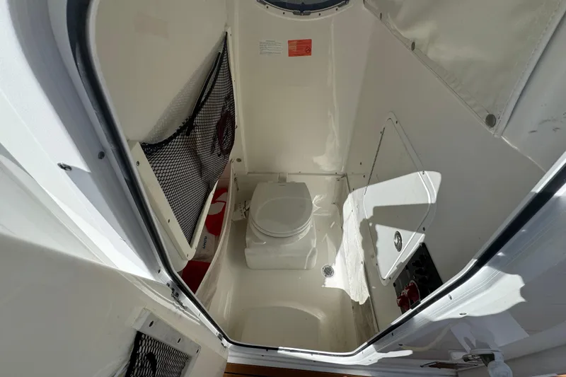 Slide: The Image of 2019 Sea Hunt Ultra 275 SE boat interior with compact marine toilet. - 20