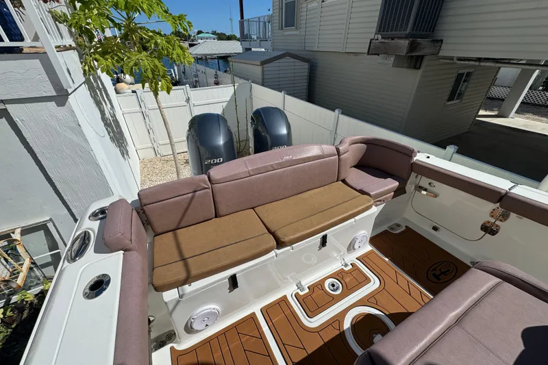 Slide: The Image of 2019 Sea Hunt Ultra 275 SE boat interior with cushioned seating and twin outboard motors. - 26