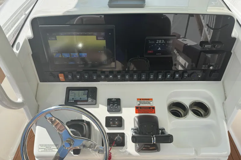 Slide: The Image of 2019 Sea Hunt Ultra 275 SE boat dashboard with steering wheel and electronic controls. - 30