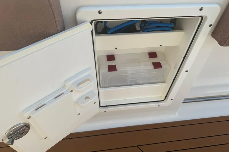 Slide: The Image of Open storage compartment on 2019 Sea Hunt Ultra 275 SE boat, featuring organized interior. - 33