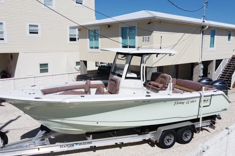 Slide: The Image of 2019 Sea Hunt Ultra 275 SE boat on trailer near coastal homes. - 4