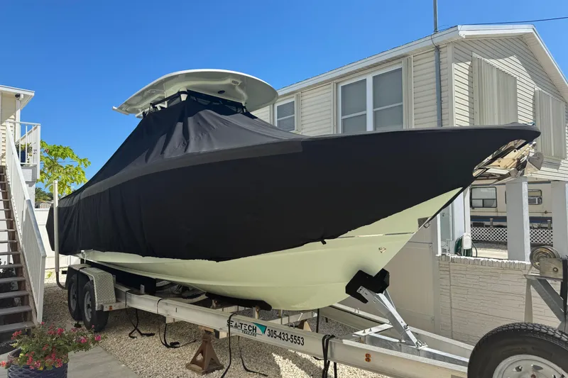 Slide: The Image of 2019 Sea Hunt Ultra 275 SE boat on trailer, covered, near residential area. - 7