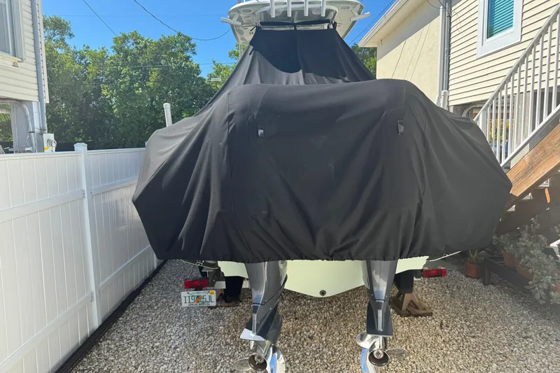 Slide: The Image of 2019 Sea Hunt Ultra 275 SE boat covered, parked in a residential driveway. - 8