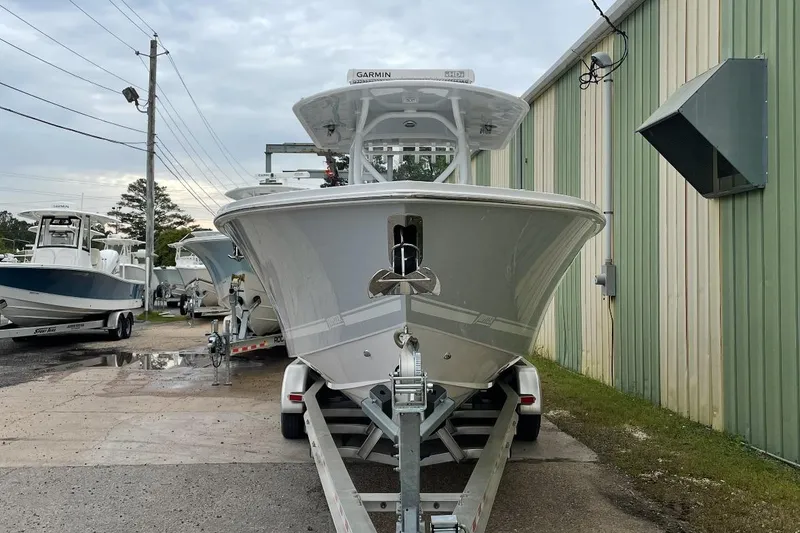 Slide: The Image of 2023 Jupiter 32 boat on trailer, parked outside a green building. - 3