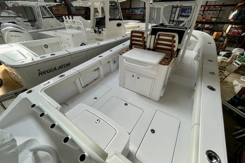Slide: The Image of 2023 Jupiter 32 boat interior with seating and storage, docked alongside a Regulator vessel. - 4