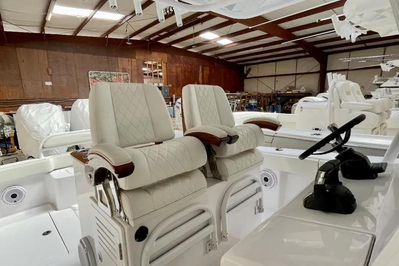 Slide: The Image of 2023 Jupiter 32 boat interior with luxurious white seating and steering wheel. - 6