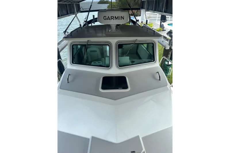 Slide: The Image of 2024 Parker 2820 XLD Sport Cabin boat with Garmin equipment, docked near water. - 11