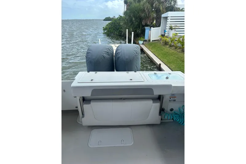 Slide: The Image of 2024 Parker 2820 XLD Sport Cabin boat with covered engines by the water. - 13