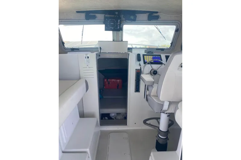 Slide: The Image of 2024 Parker 2820 XLD Sport Cabin interior with helm, seating, and navigation equipment. - 3