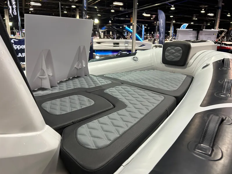 Slide: The Image of 2025 Highfield Sport 560 boat interior with gray cushioned seating at a boat show. - 20