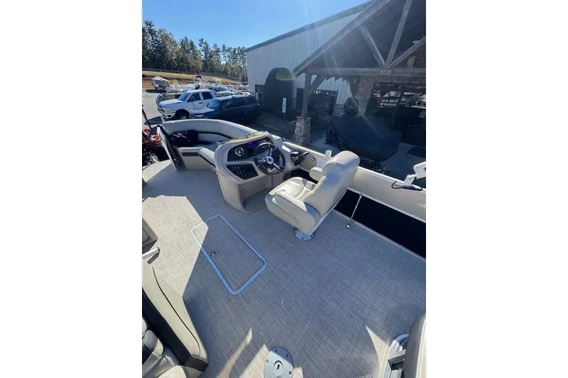 Slide: The Image of 2020 South Bay 200 boat interior with steering console and seating, parked outdoors. - 11
