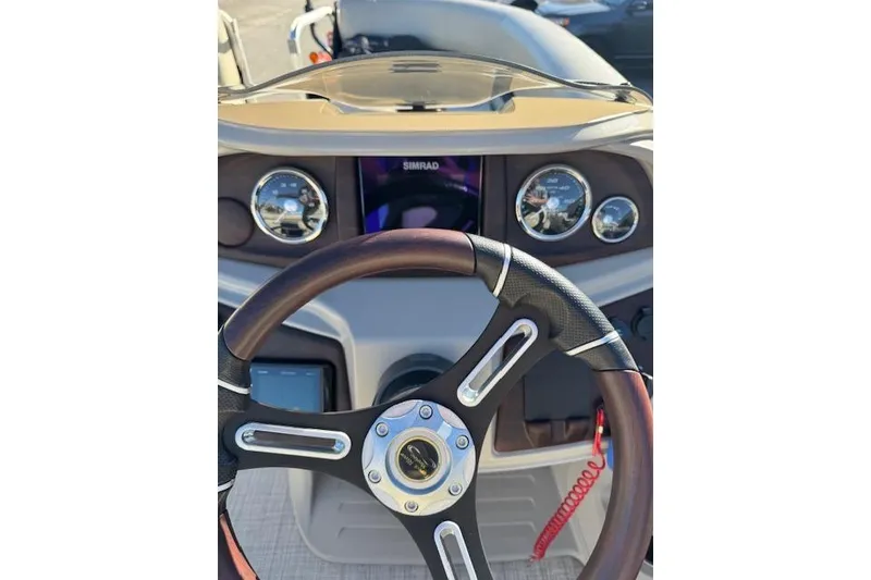 Slide: The Image of Steering wheel and dashboard of 2020 South Bay 200 boat with gauges and controls. - 13