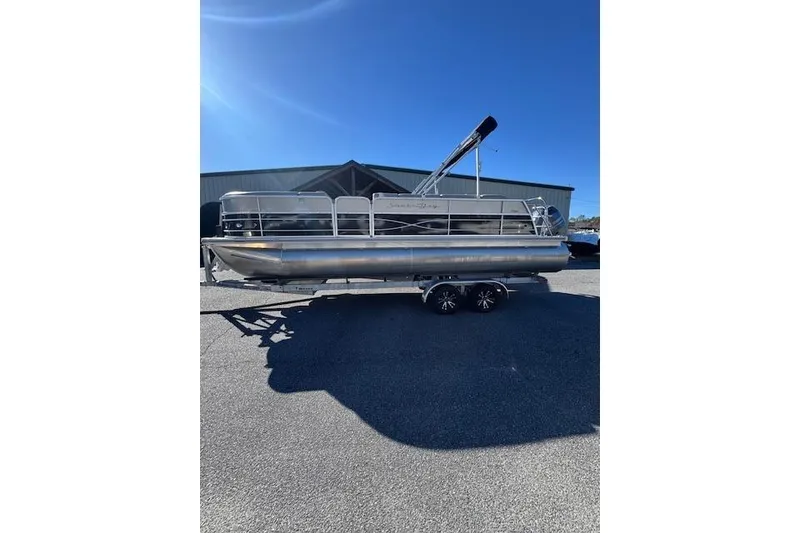 Slide: The Image of 2020 South Bay 200 pontoon boat on trailer under clear blue sky. - 4