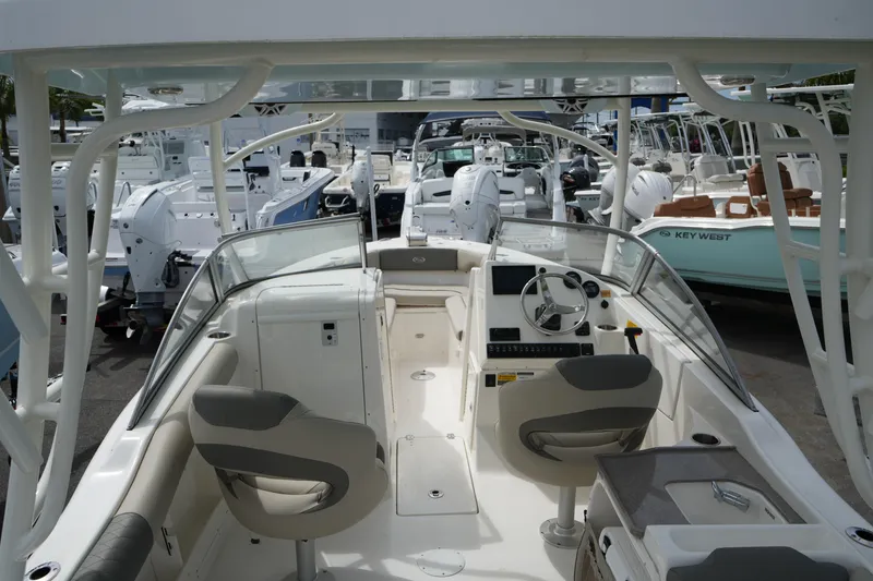 Slide: The Image of 2026 Key West 239 DFS boat interior with helm, seats, and dashboard in a marina. - 12