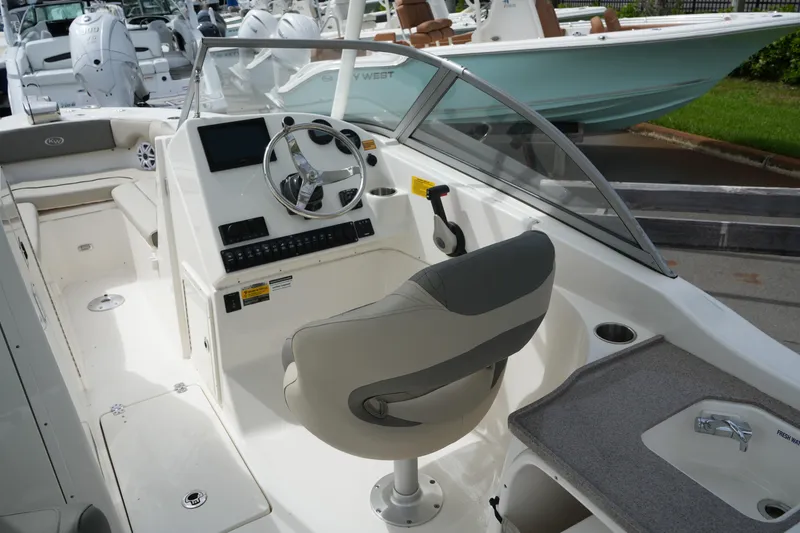 Slide: The Image of 2026 Key West 239 DFS boat interior with steering wheel and seating. - 16