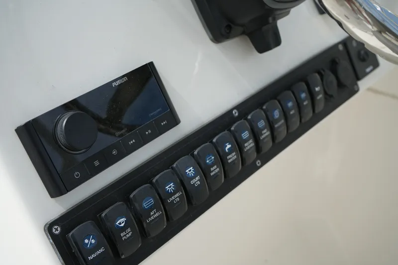 Slide: The Image of Control panel of 2026 Key West 239 DFS boat with switches and audio system. - 19