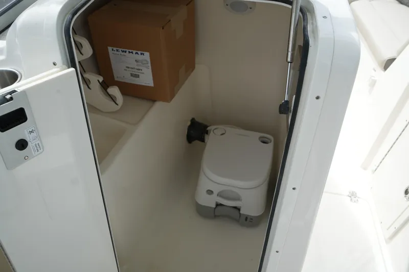 Slide: The Image of Interior of 2026 Key West 239 DFS boat with portable toilet and storage box. - 29