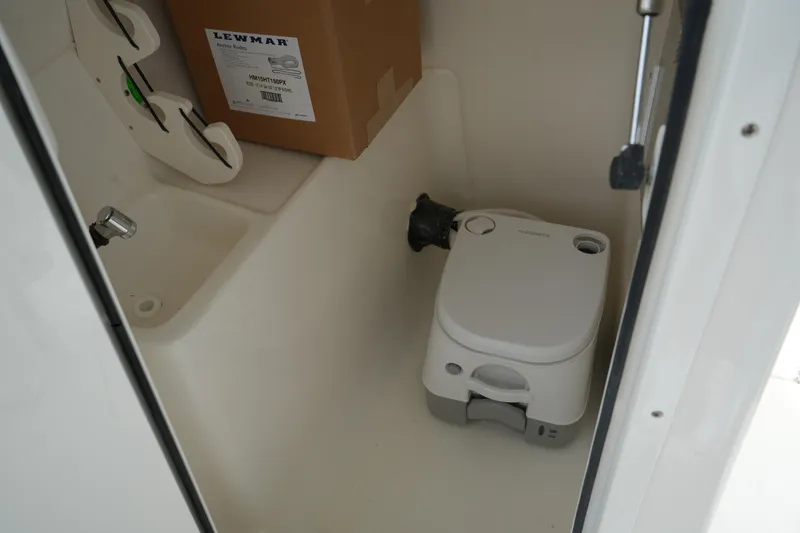 Slide: The Image of Storage compartment in a 2026 Key West 239 DFS boat with portable toilet and Lewmar box. - 30