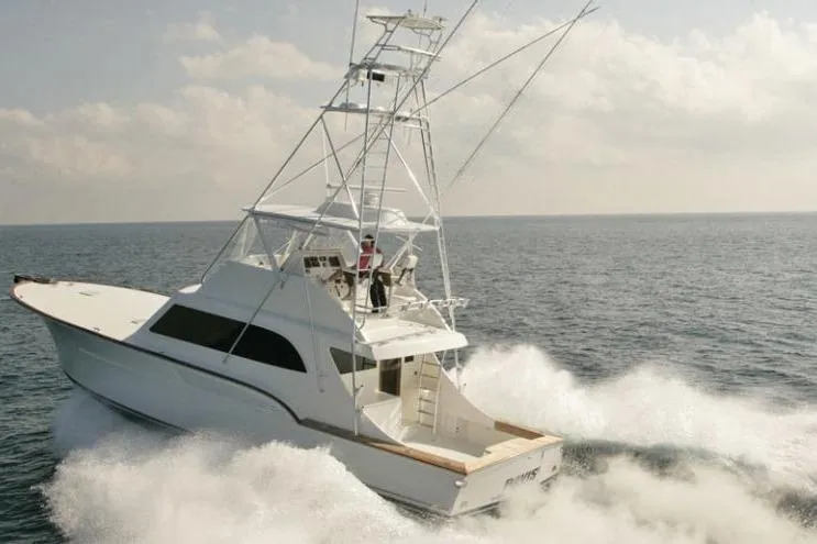 Slide: The Image of 2026 Buddy Davis 58 Sportfisherman cruising on open sea, creating waves. - 3