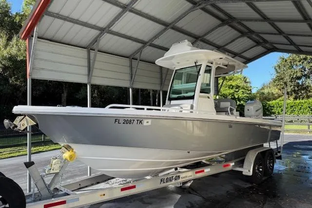 Slide: The Image of 2023 Everglades 253 Center Console boat on trailer under a metal canopy. - 12