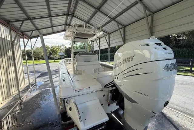 Slide: The Image of 2023 Everglades 253 Center Console boat with Mercury 400 engine under a metal canopy. - 14