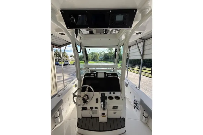 Slide: The Image of 2023 Everglades 253 Center Console boat interior with steering wheel and control panel. - 17