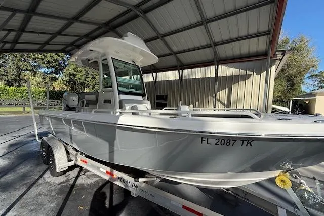 Slide: The Image of 2023 Everglades 253 Center Console boat on trailer under metal shelter. - 2