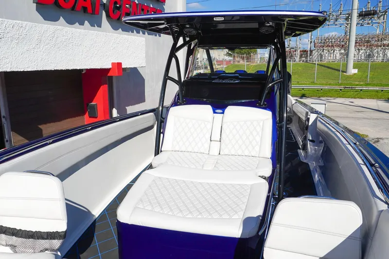 Slide: The Image of 2020 Nor-Tech 390 Center Console boat with white seating, docked near a boat center. - 11